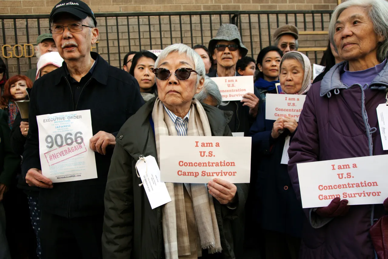 A number of people standing together holding banners